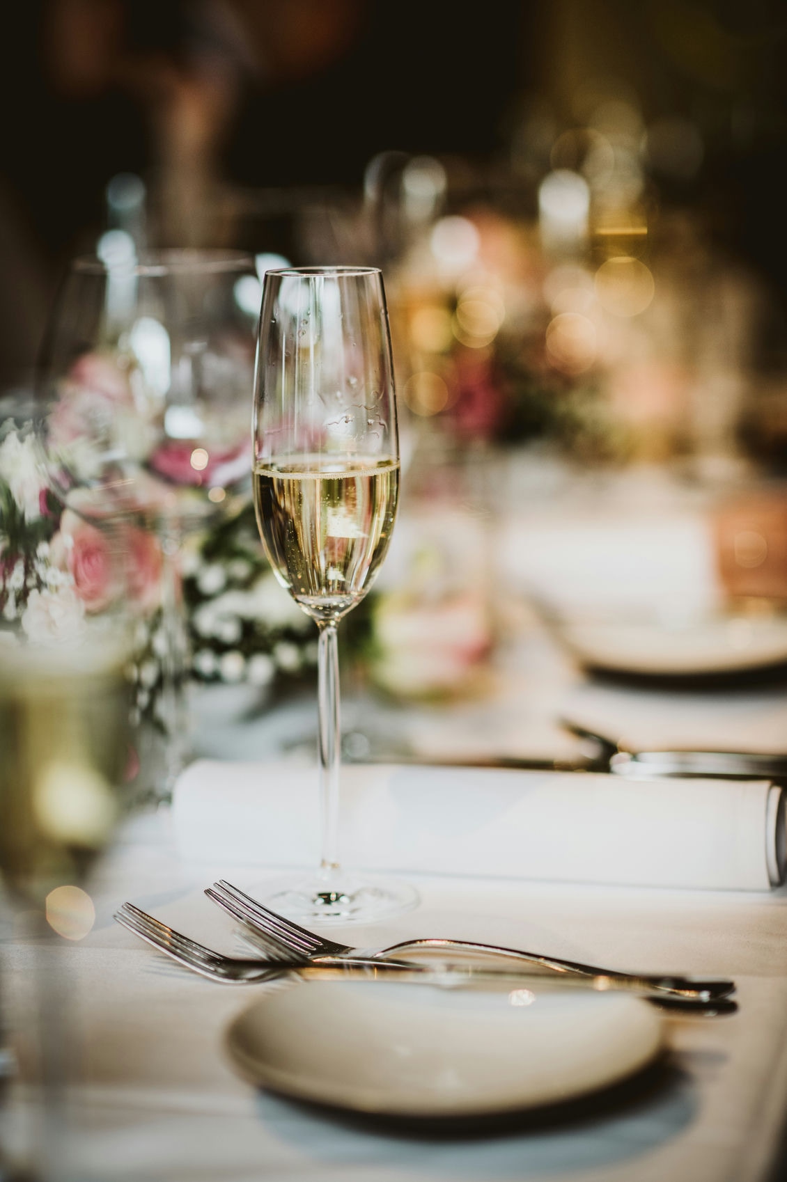 Plan rapproché sur une coupe de champagne sur une table dressée du restaurant à Charols au coeur du Château Les Oliviers de Salettes